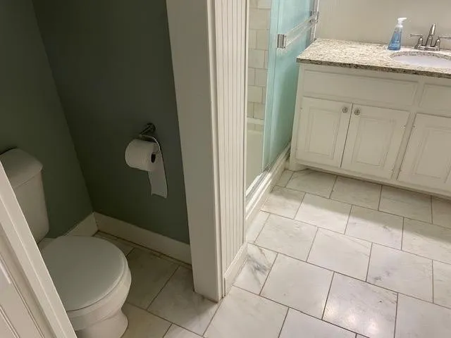 a bathroom with a granite countertop sink and shower