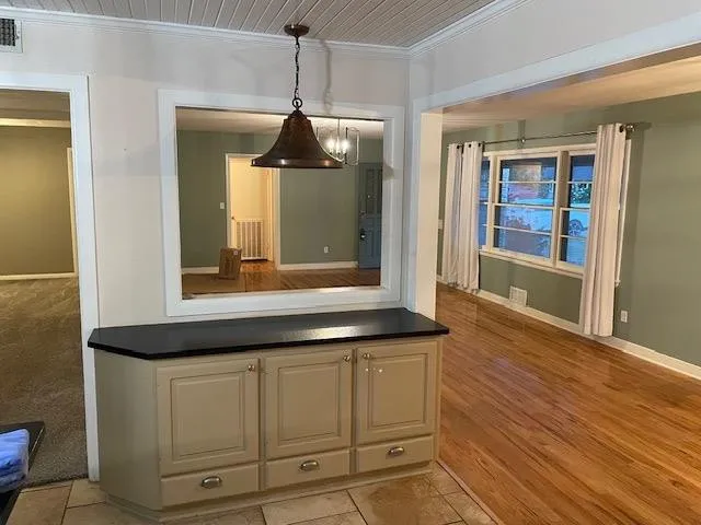 a view of a hallway with wooden floor and cabinet