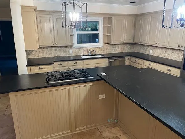 a kitchen with granite countertop a sink a stove and cabinets
