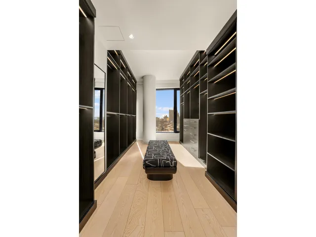 a hallway with a black white checkered floor and a potted plant