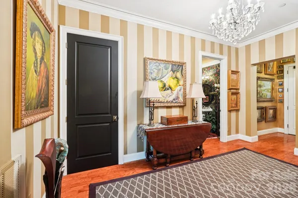 a view of a dining room with furniture a chandelier and large windows