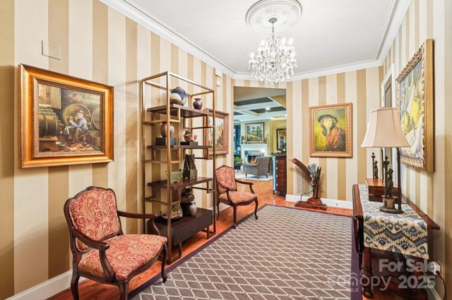 a living room with furniture a chandelier and a painting on the wall