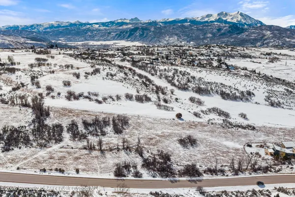 a view of a dry field with mountains in the background