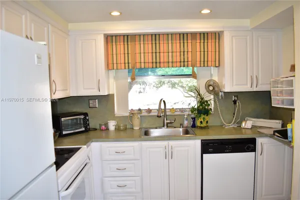 a kitchen with white cabinets and white appliances