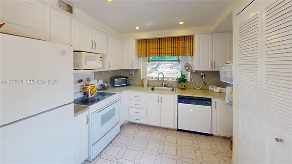 a kitchen with white cabinets and white appliances