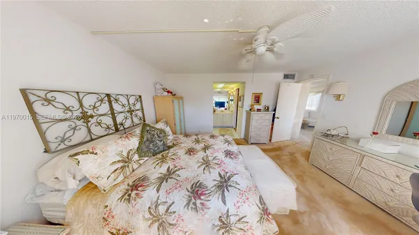 a spacious bedroom with a large bed and a chandelier