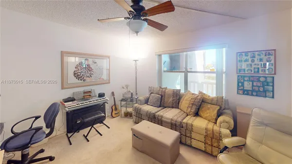 a living room with furniture a flat screen tv and a window