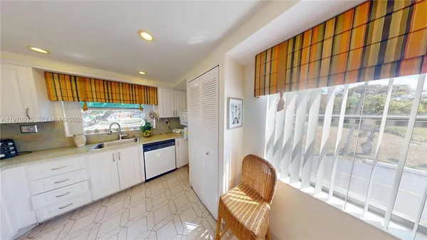 a kitchen with granite countertop cabinets a sink a window and stainless steel appliances