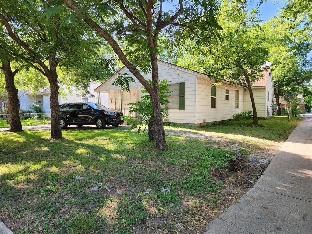 8727 Eldon Drive Dallas, TX 75217 - Photo 1 of 1 a view of a yard in front of a house with large trees