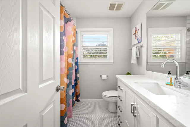 a bathroom with a sink a toilet and a window