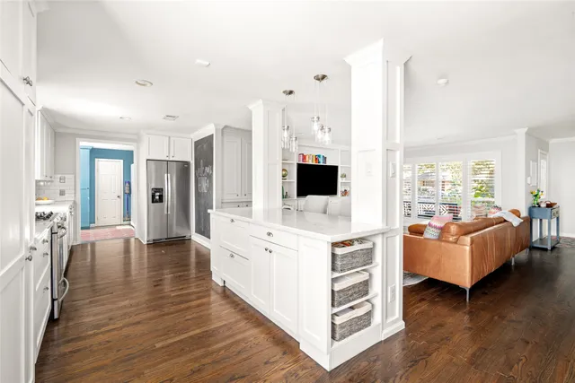 a large white kitchen with a large window and stainless steel appliances