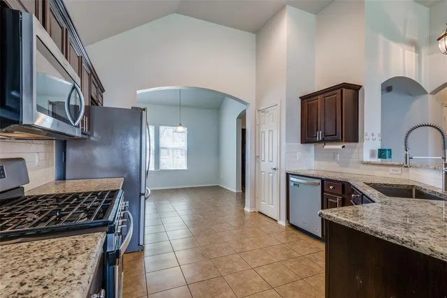 a kitchen with stainless steel appliances granite countertop a sink stove and cabinets