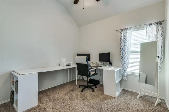 a view of a workspace with furniture and a window