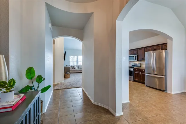 a hallway with a refrigerator and a sink