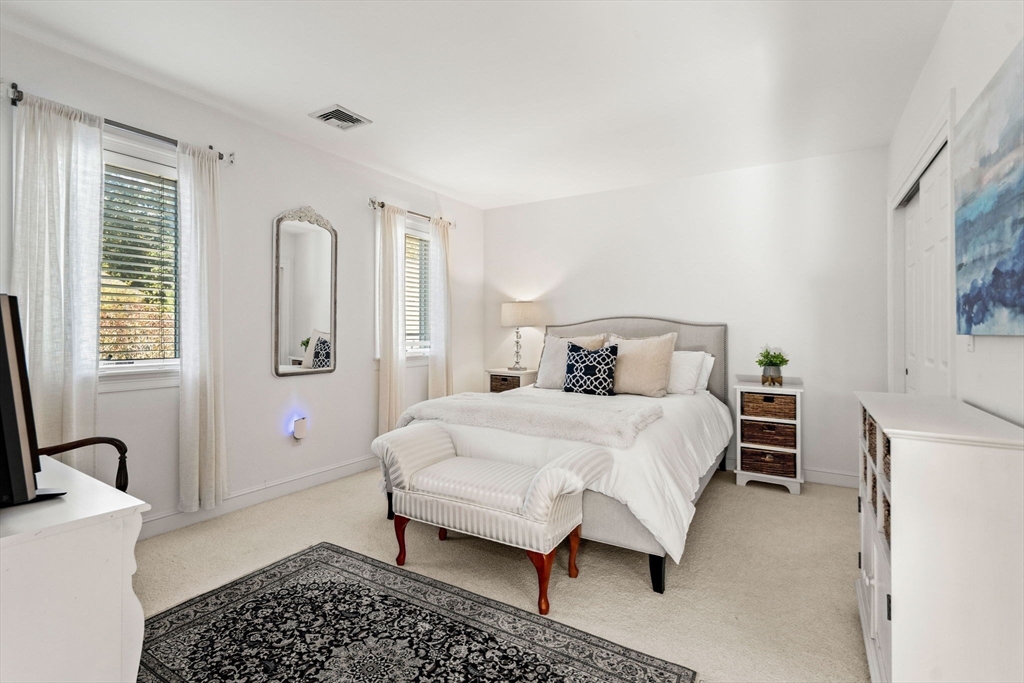 12 Highwood Lane Ipswich, MA 01938 - Photo 28 of 42 a bedroom with a bed and a table with mirror