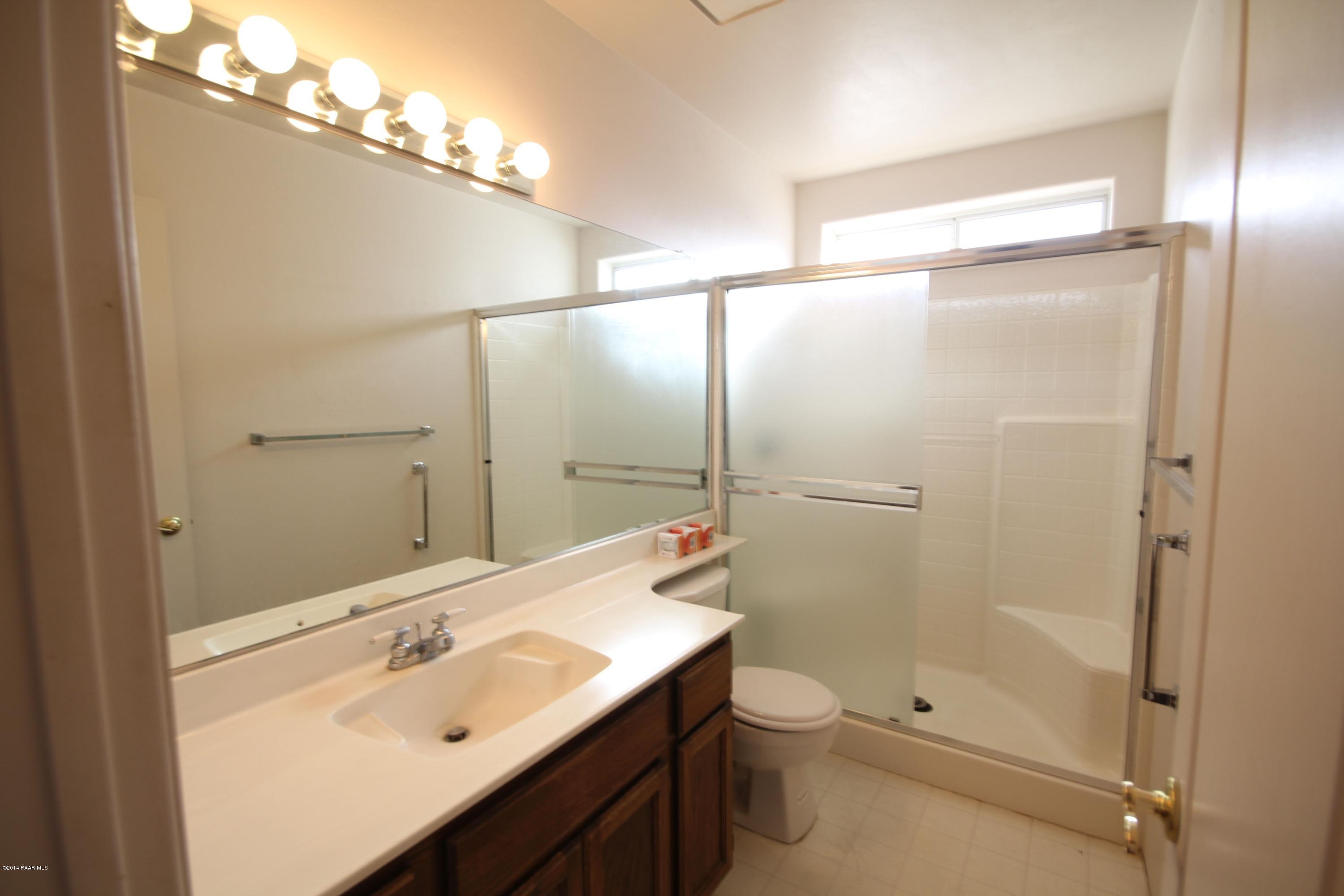 3221 North Reed Road Chino Valley, AZ 86323 - Photo 15 of 24 a bathroom with a sink mirror toilet and shower