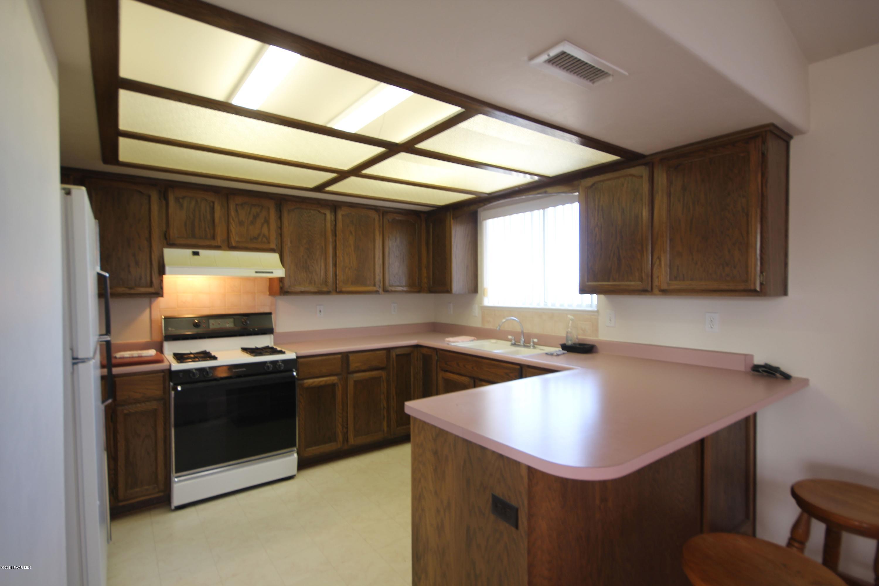 3221 North Reed Road Chino Valley, AZ 86323 - Photo 5 of 24 a kitchen with a sink a stove and cabinets