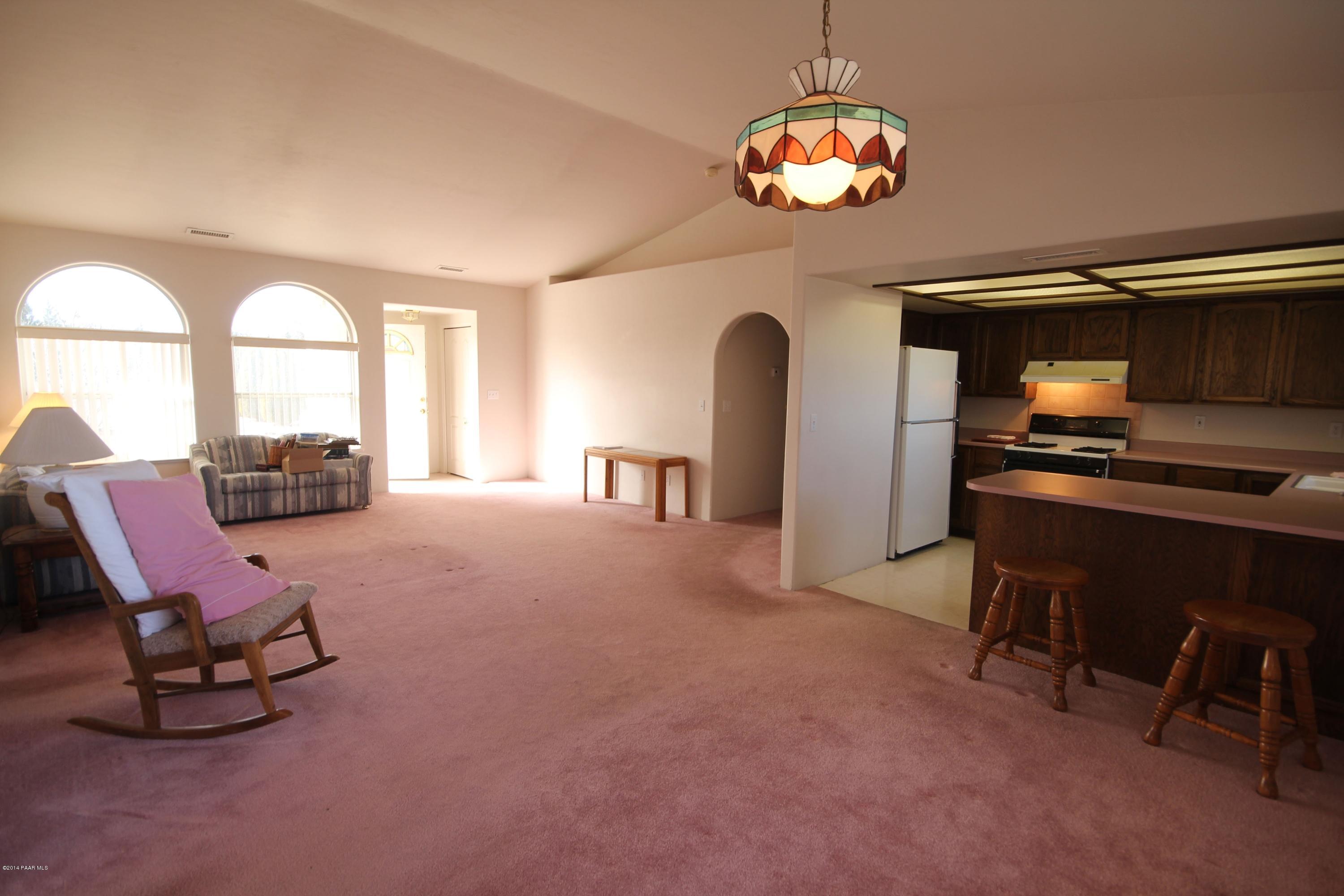 3221 North Reed Road Chino Valley, AZ 86323 - Photo 7 of 24 a living room with furniture a dining table and a chandelier