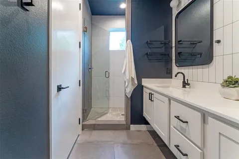 a spacious bathroom with a double vanity sink a mirror and a shower