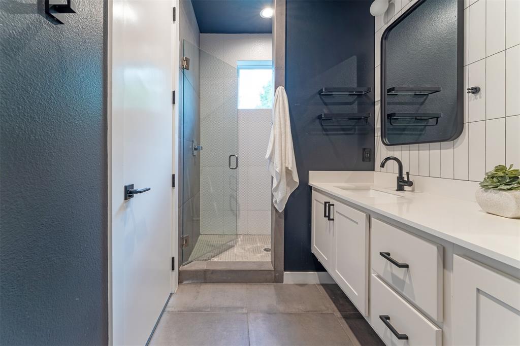 4620 Munger Avenue, Unit 107 Dallas, TX 75204 - Photo 15 of 28 a spacious bathroom with a double vanity sink a mirror and a shower
