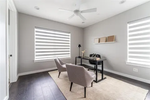 a view of a workspace with furniture and a window