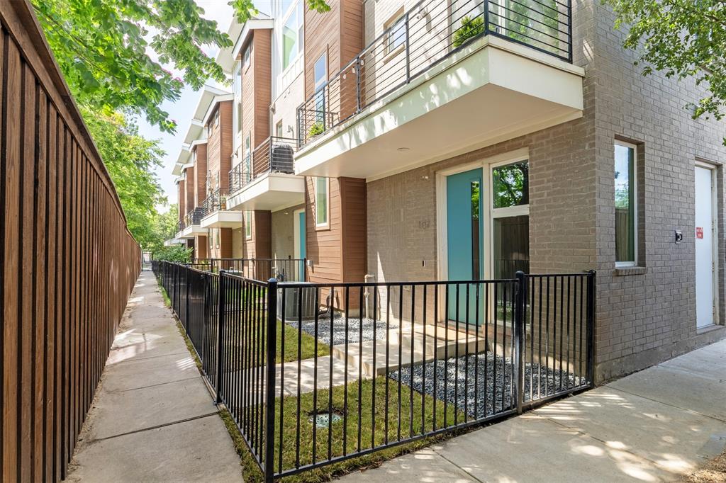 4620 Munger Avenue, Unit 107 Dallas, TX 75204 - Photo 25 of 28 a view of a brick house with a small yard and wooden fence