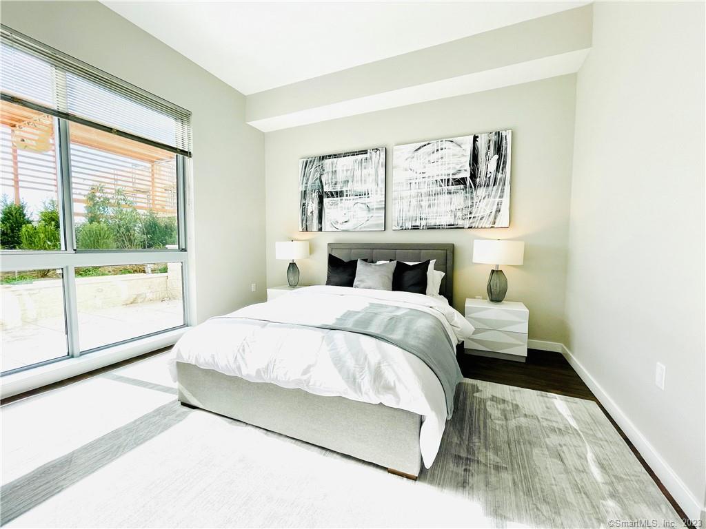 900 Pacific Street, Unit 322 Stamford, CT 06902 - Photo 3 of 8 a bedroom with a large bed and a large window