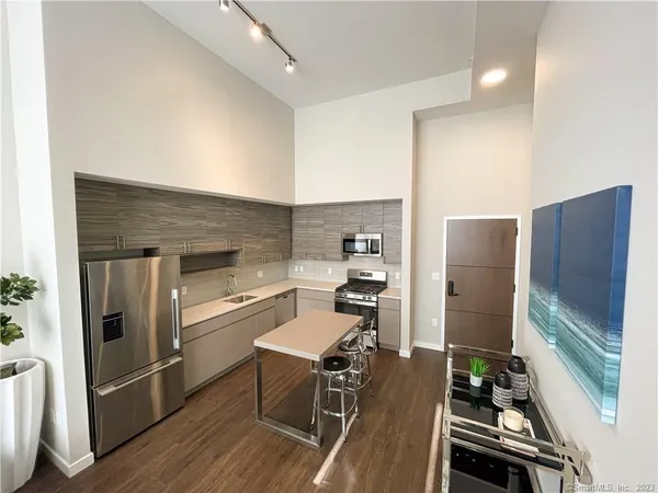 a kitchen with wooden floor and stainless steel appliances