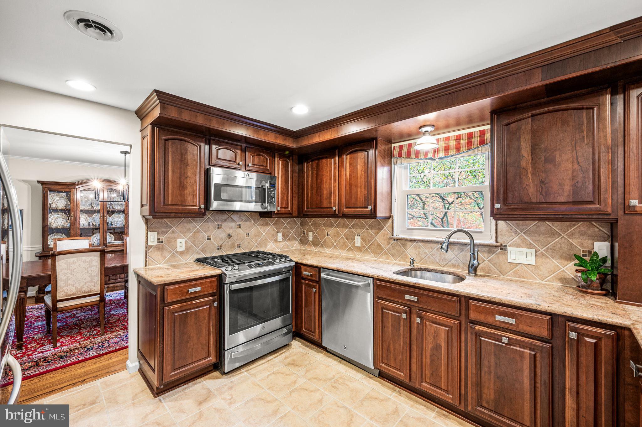 509 Lawrence Drive Springfield, PA 19064 - Photo 15 of 37 a kitchen with stainless steel appliances granite countertop a sink stove and cabinets