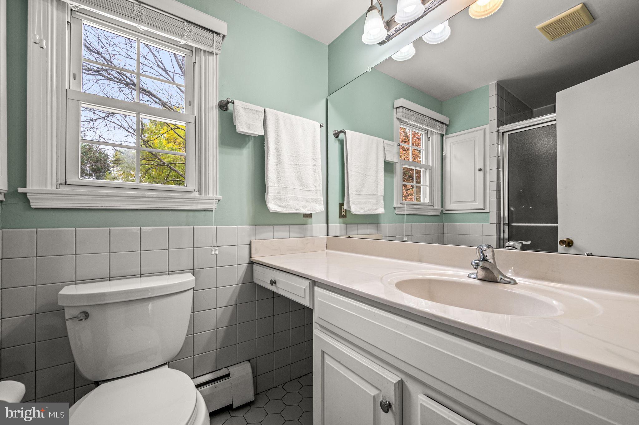 509 Lawrence Drive Springfield, PA 19064 - Photo 29 of 37 a bathroom with a toilet a sink and a large mirror