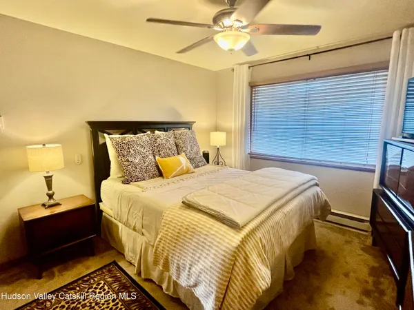 a bedroom with a bed and a flat tv screen on dresser