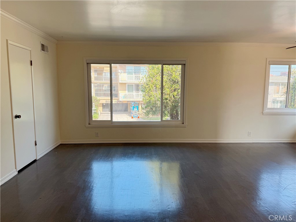2030 East 3rd Street, Unit 5 Long Beach, CA 90814 - Photo 5 of 23 a view of an empty room with wooden floor and a window