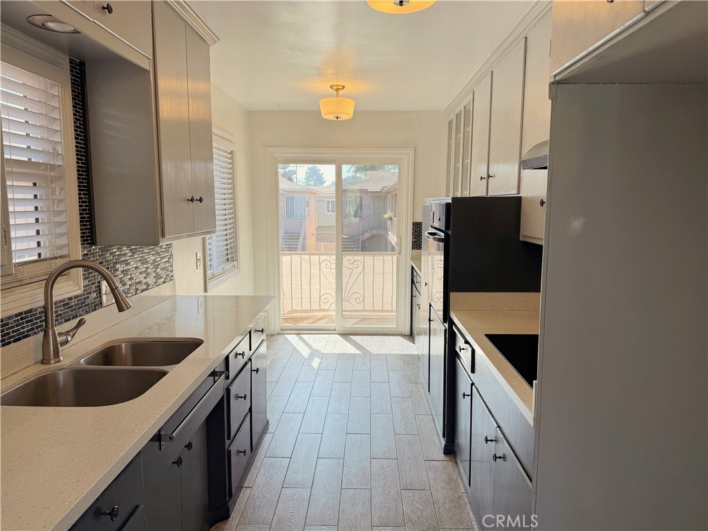 2030 East 3rd Street, Unit 5 Long Beach, CA 90814 - Photo 7 of 23 a kitchen with granite countertop a sink and a refrigerator