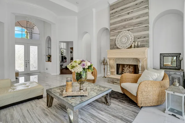 a living room with furniture a table and a large window