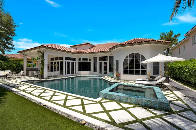 a view of a house with pool and chairs