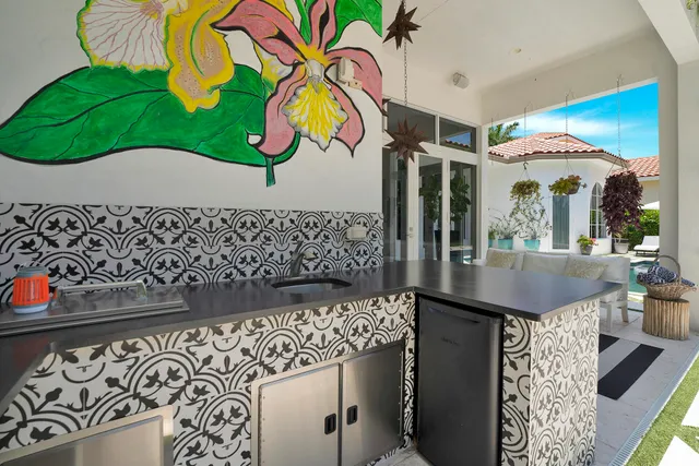 a view of a patio with couches and chairs under an umbrella with a fire pit