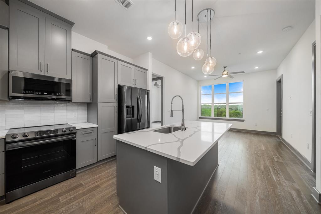 2700 Old Denton Road, Unit 3336 Carrollton, TX 75007 - Photo 7 of 29 a kitchen with stainless steel appliances granite countertop a sink stove and refrigerator