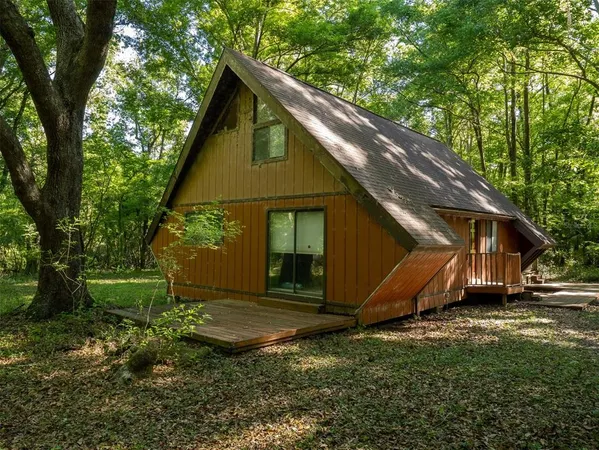 a view of backyard with wooden fence and a large tree