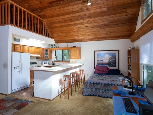 a kitchen with kitchen island granite countertop a stove a sink and a refrigerator