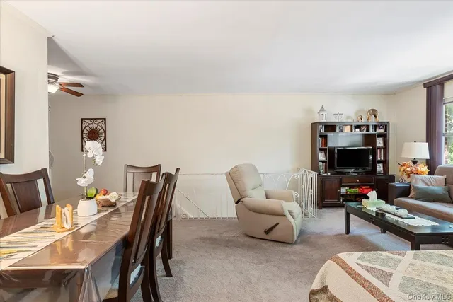 a living room with furniture a flat screen tv and a window