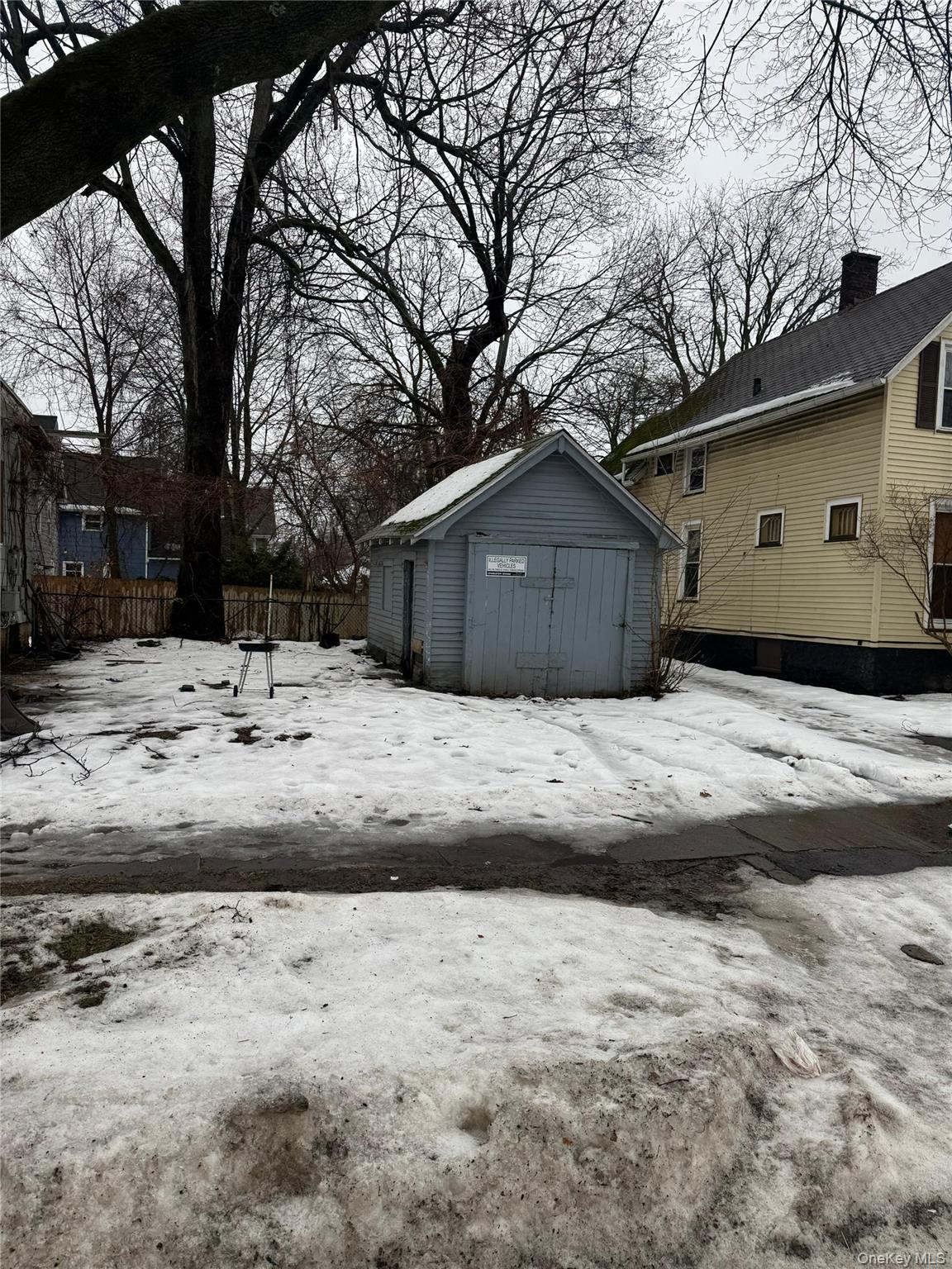 277 Lexington Avenue Rochester, NY 14613 - Photo 4 of 4 Yard covered in snow featuring a storage unit
