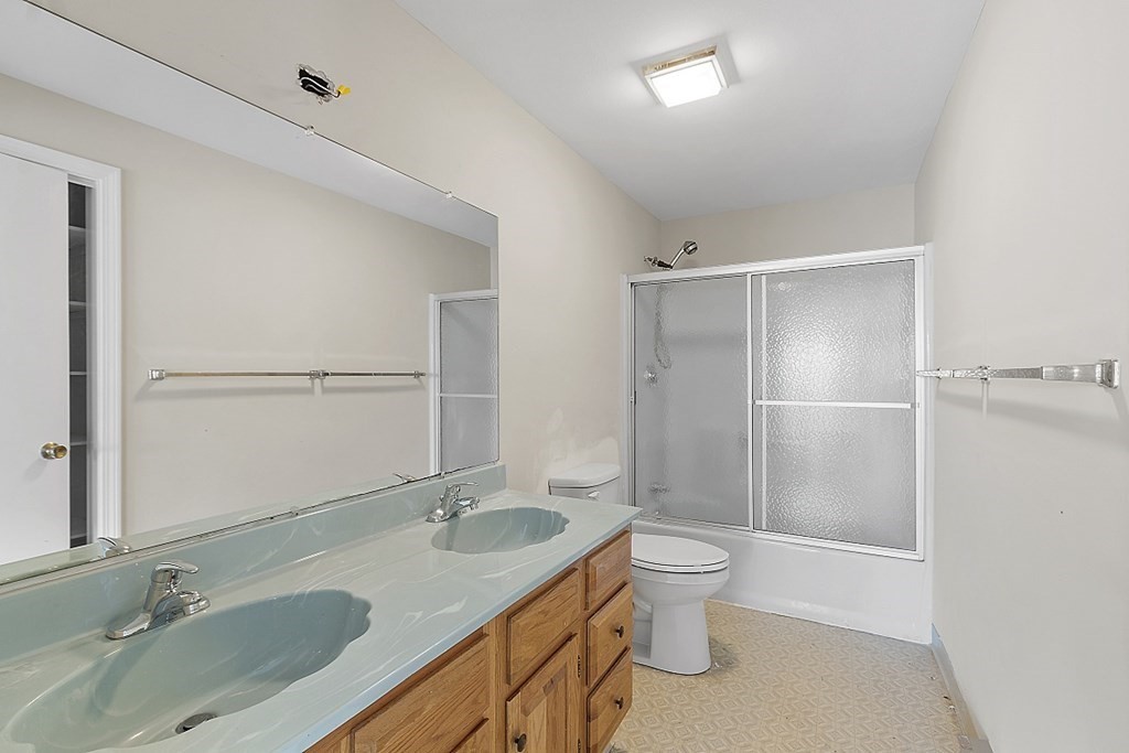 27 Ernest Avenue, Unit 24 Exeter, NH 03833 - Photo 16 of 38 a bathroom with a granite countertop sink toilet and shower