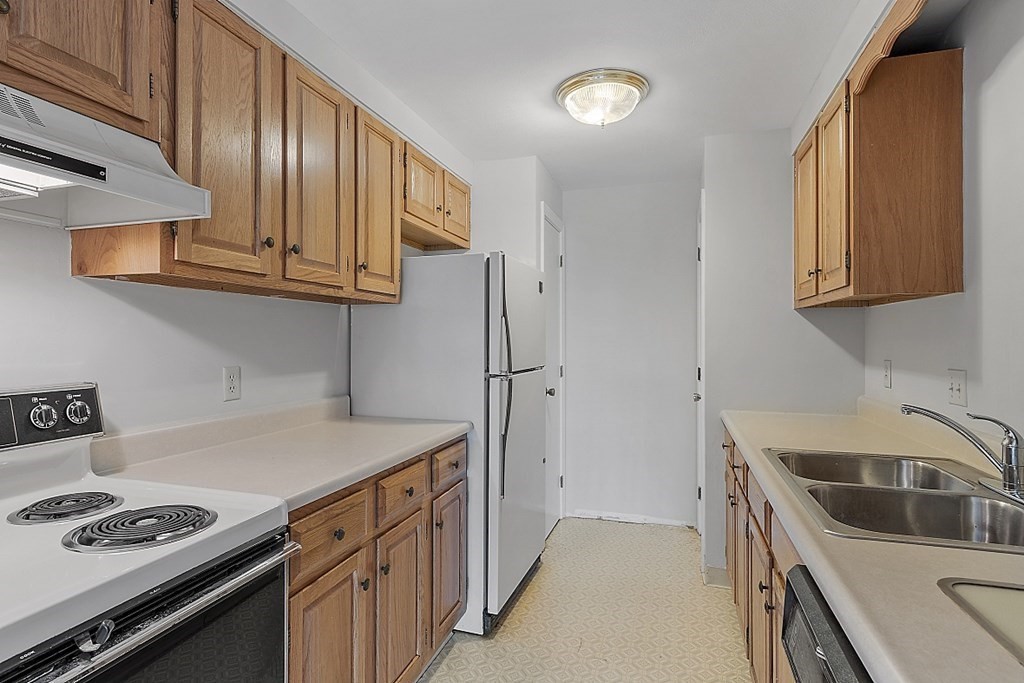 27 Ernest Avenue, Unit 24 Exeter, NH 03833 - Photo 9 of 38 a kitchen with stainless steel appliances granite countertop a sink stove and refrigerator