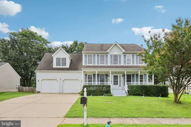 a front view of a house with a garden and yard