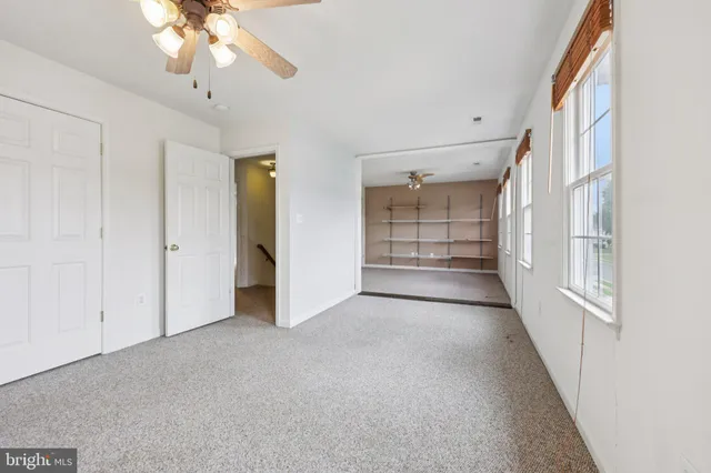 a spacious bedroom with a bed and a ceiling fan