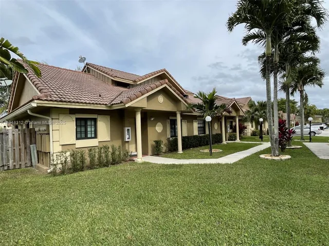 a view of a house with a small yard and plants