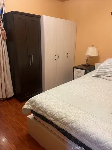 a bedroom with a bed and wooden floor