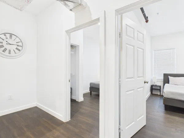a view of a bedroom with furniture and wooden floor