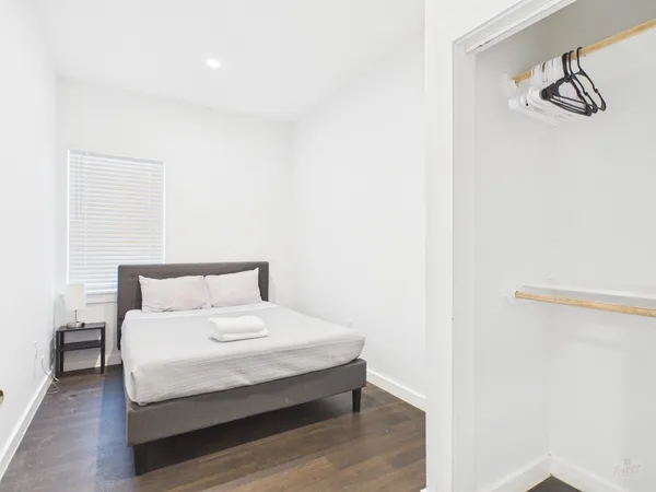 a large bed sitting in a bedroom next to a window