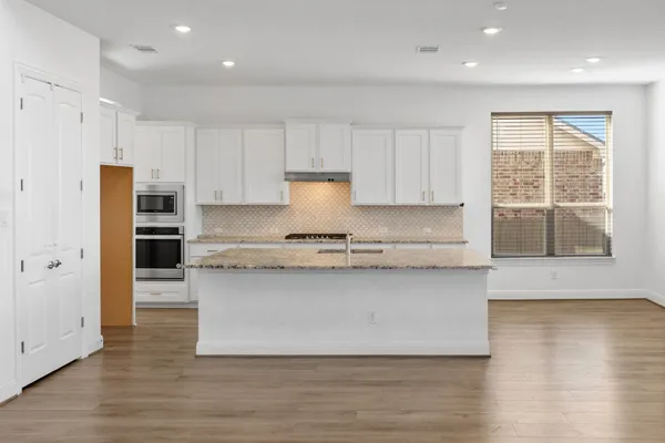 a kitchen with stainless steel appliances granite countertop a stove a sink and a refrigerator